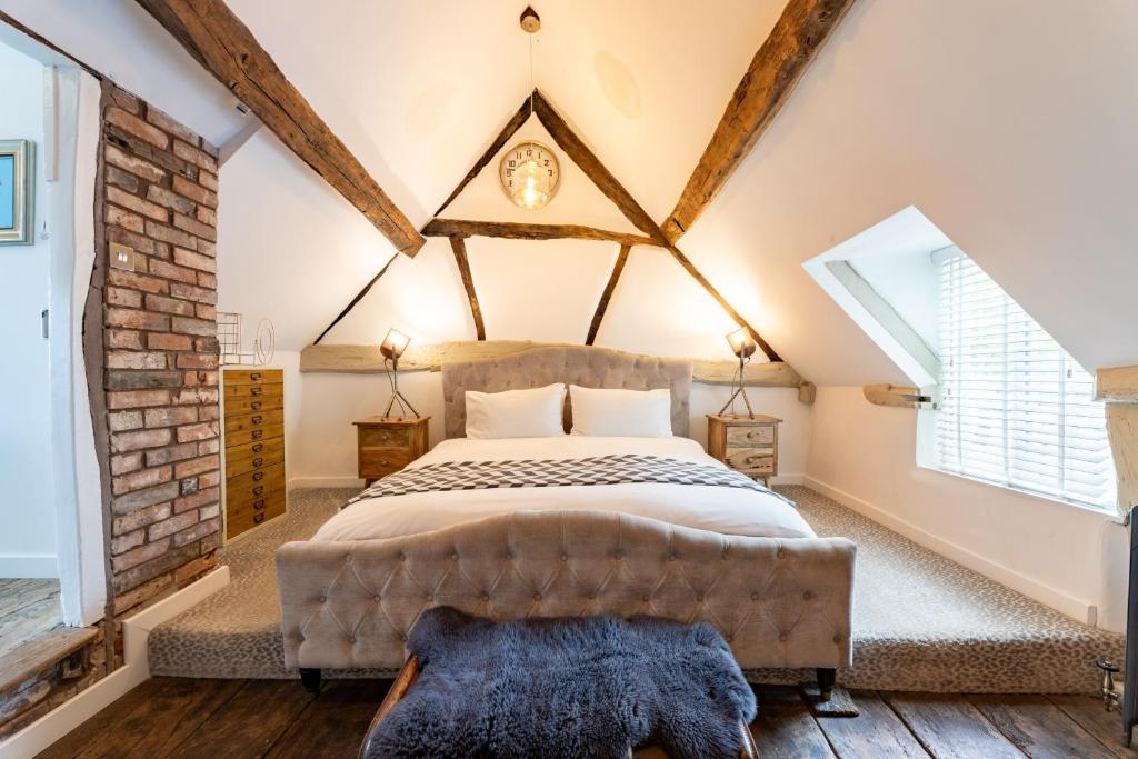 1 dormitorio con cama y pared de ladrillo en The Art Studio en Henley in Arden
