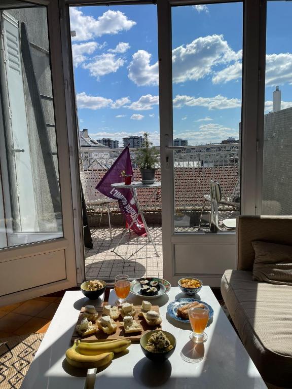 une table avec de la nourriture au-dessus d'une pièce avec une fenêtre dans l'établissement Nice 2 bedrooms flat in the center of Paris with terrasse and incredible view, à Paris