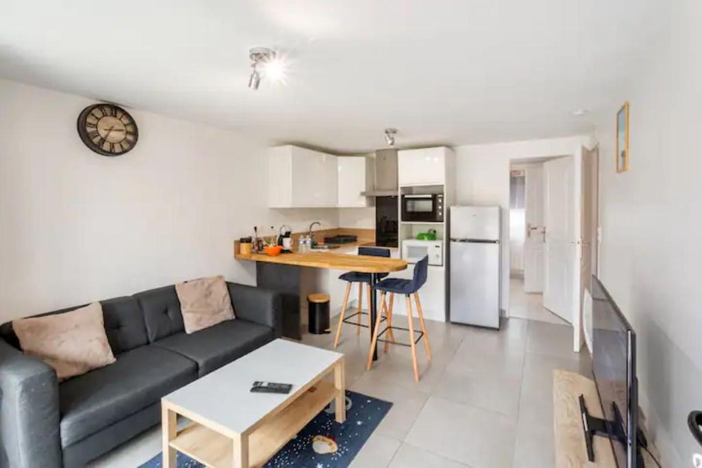 een woonkamer met een bank en een keuken bij Studio cosy proche Paris Orly in Morangis
