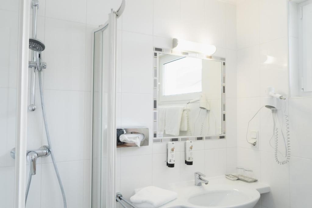 bagno bianco con lavandino e specchio di KRACHER Apartment No 1 a Illmitz