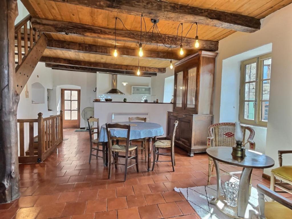 une cuisine et une salle à manger avec une table et des chaises dans l'établissement Maison de la Fontaine, à Valleraugue