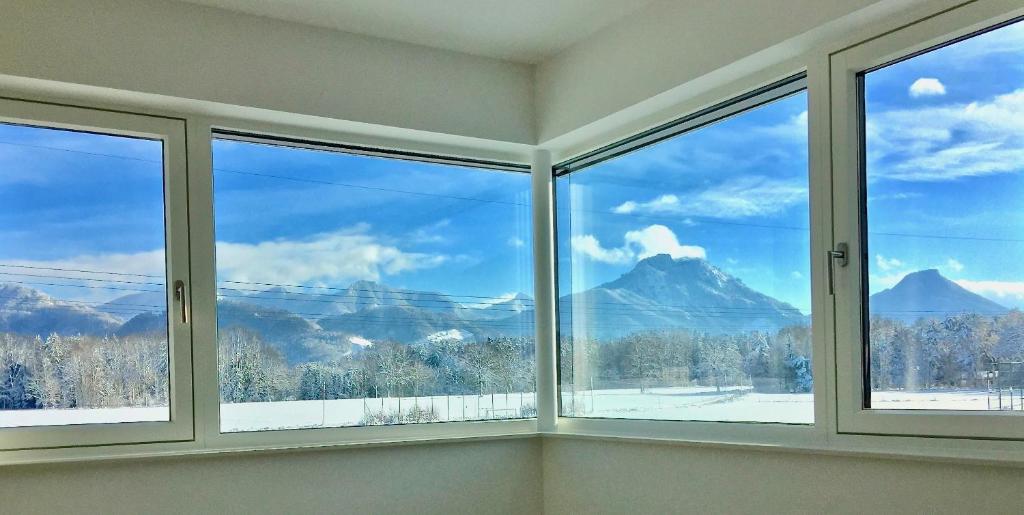 a room with four windows with a view of mountains at Ferienwohnung Black White in Raubling