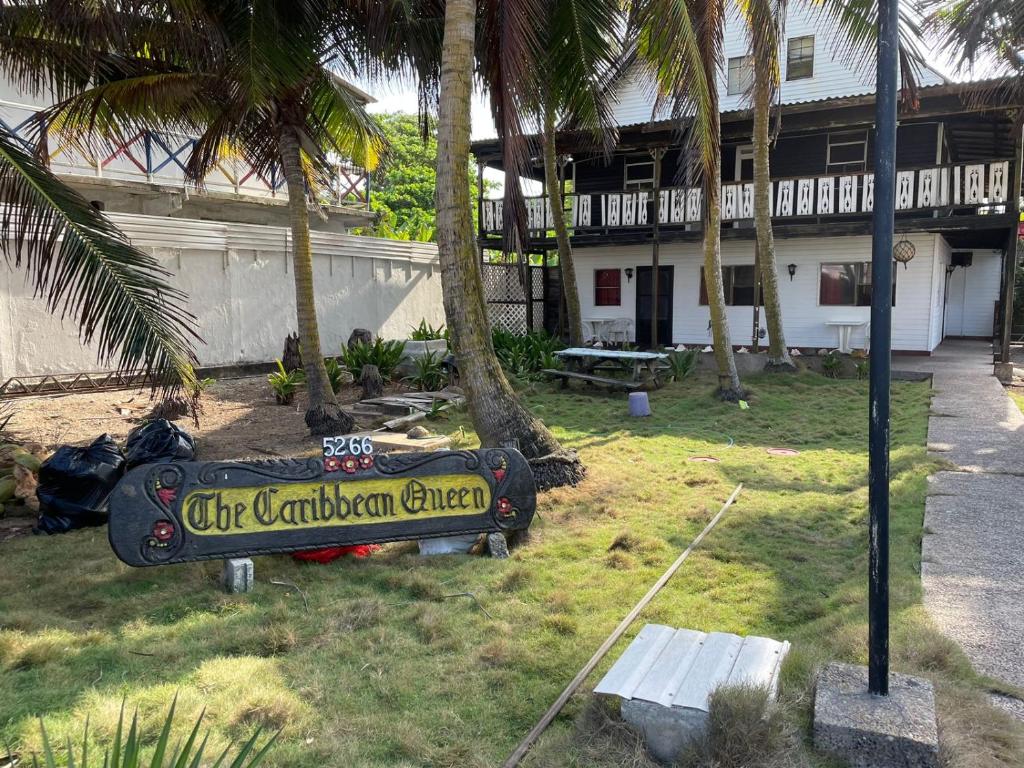 una señal frente a un edificio con palmeras en Caribbean Queen en San Andrés
