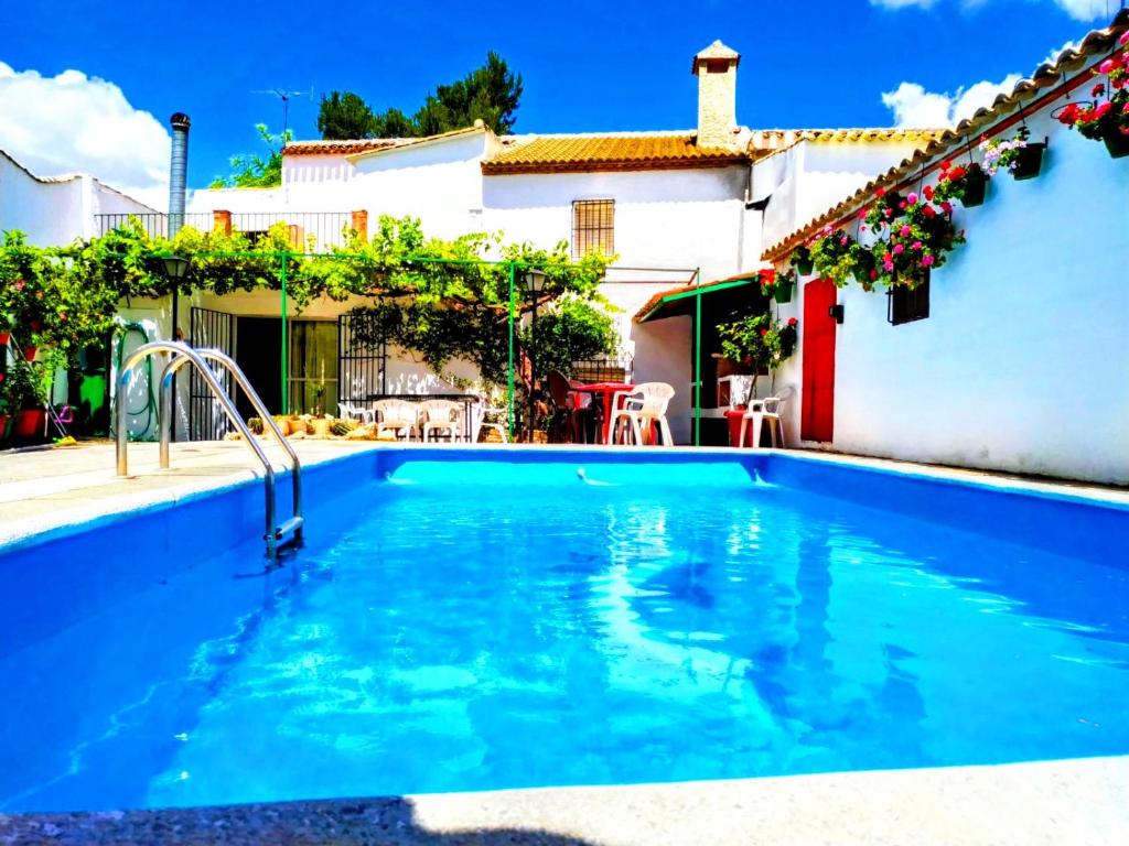 a swimming pool in front of a house at Casa Rural Patio Andaluz in Campo-Nubes