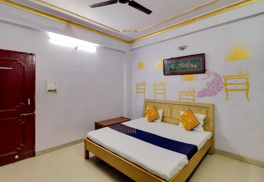 a bedroom with a bed and a tv on the wall at J C Guest House in Hasanganj