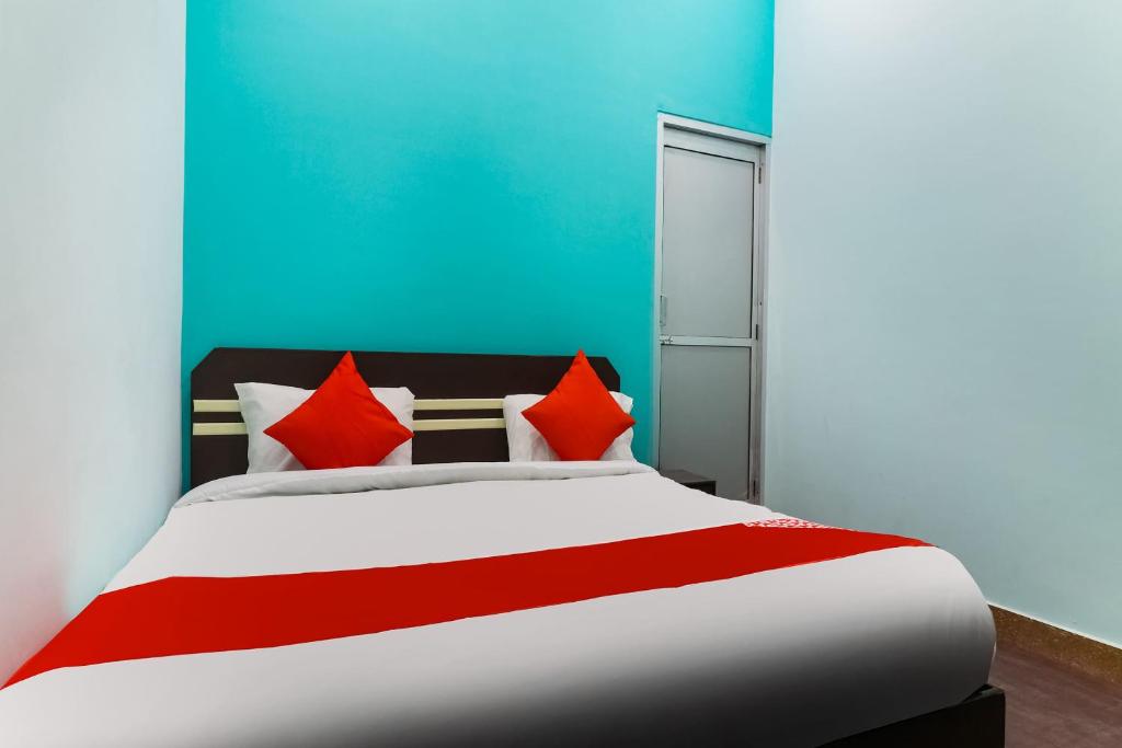 Bhiwāni的住宿－OYO Shree Shyam Roseberry Hotel And Restaurant，一间卧室配有红色枕头的床