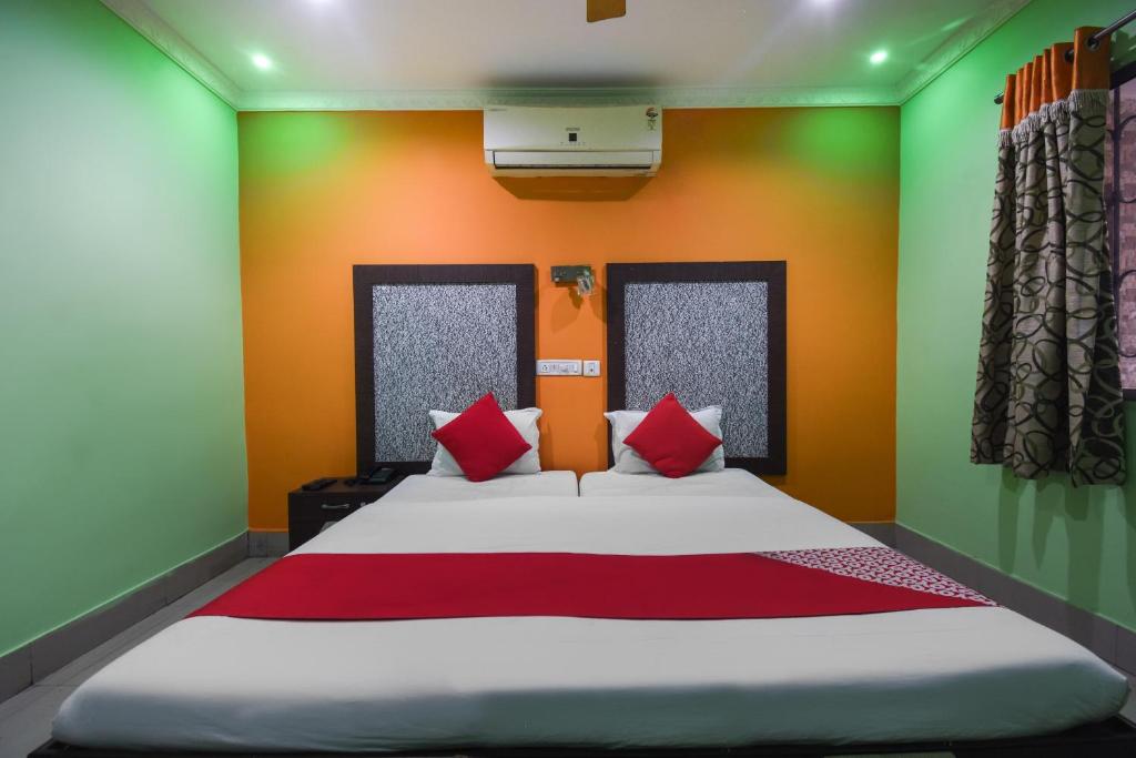 a bedroom with a bed with red and green walls at Hotel Kohinoor in Durgāpur