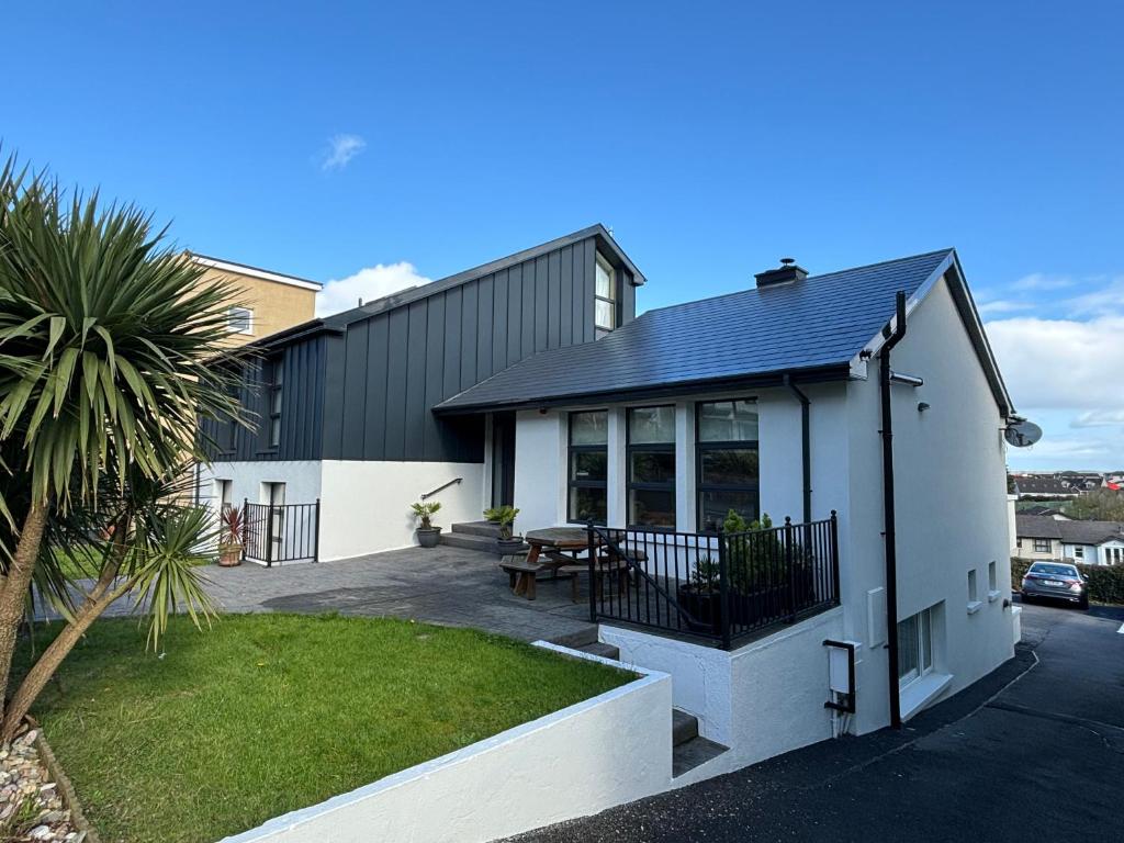 een huis met een patio en een tafel in een tuin bij Beach Haven B&B in Tramore