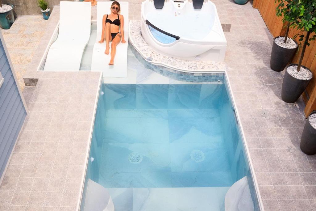 a woman in a bikini standing next to a swimming pool at 1234 New Orleans in New Orleans