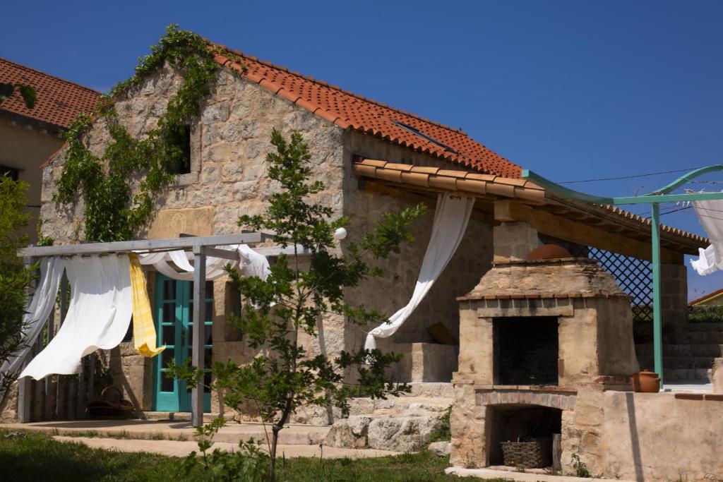 a house with a stone oven in front of it at Stonehome Pojata in Rušići
