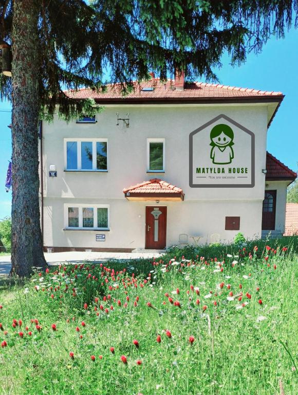 una casa con un campo de flores delante de ella en Matylda House, en Cracovia