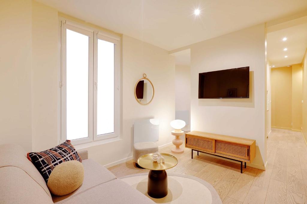 un salon avec un canapé et une télévision dans l'établissement Elegant Apartment - 1BR-2P - Arc de Triomphe, à Paris