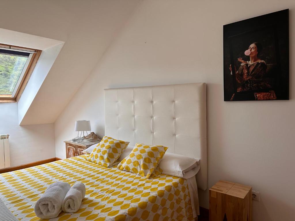 een slaapkamer met een bed met een gele en witte geruite deken bij Alianza del Castillo in Ponferrada