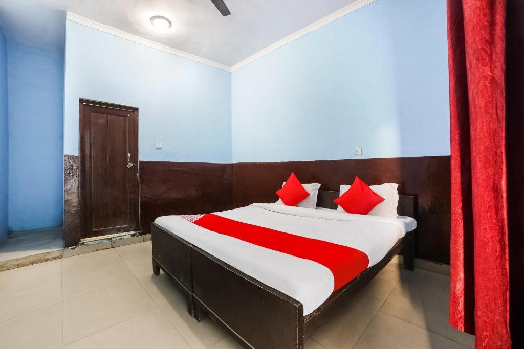 um quarto com uma cama com almofadas vermelhas em OYO 67226 Om Hotel em Neemrana
