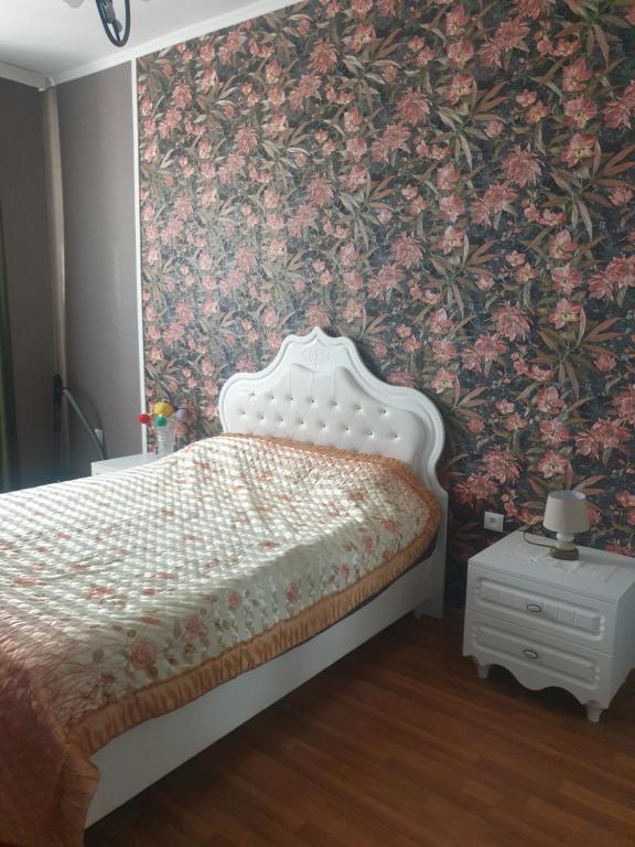 a bedroom with a bed with a floral wallpaper at KeMo121 in Zugdidi