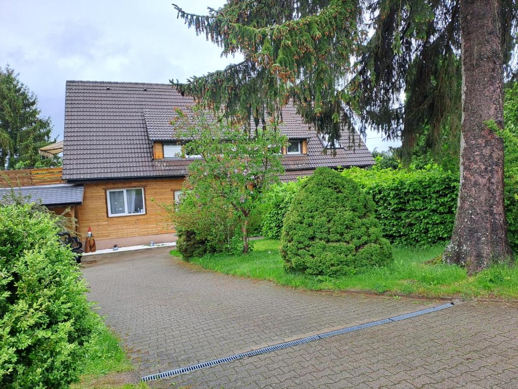 a house with a tree next to a driveway at Ferienwohnung Anna in Schramberg