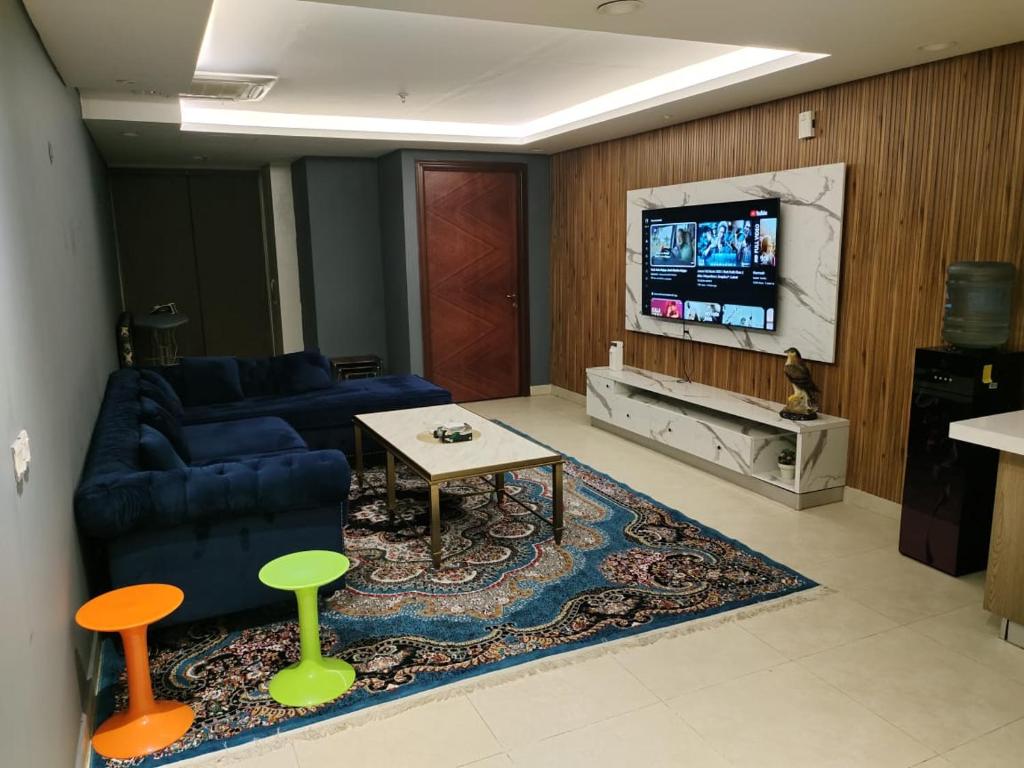 un soggiorno con divano, tavolo e TV di Couples Heaven Apartment a Lahore