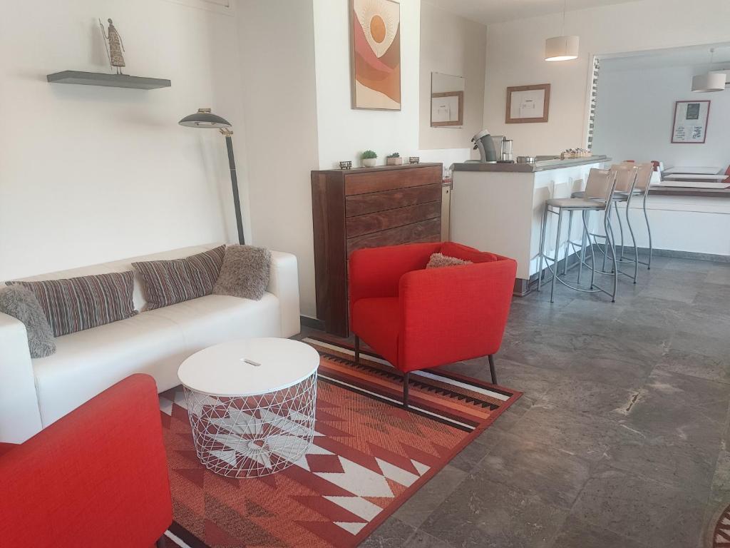 維琪奧港的住宿－雛鷹比利提斯酒店，带沙发和椅子的客厅以及厨房。