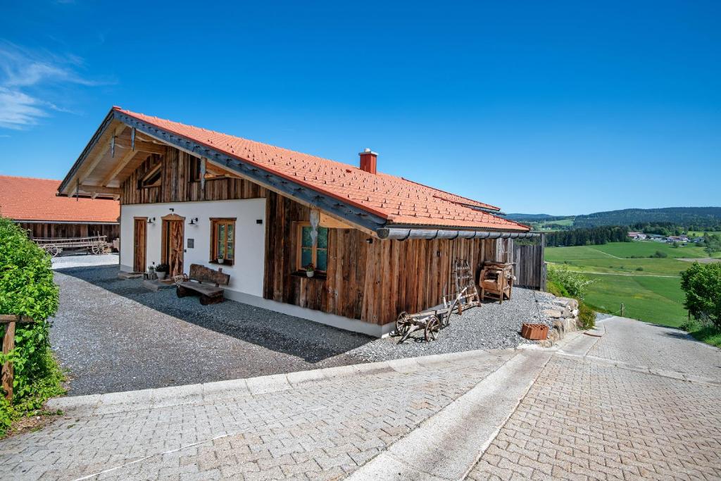 un pequeño edificio de madera con techo rojo en Bergchalet 2 en Freyung