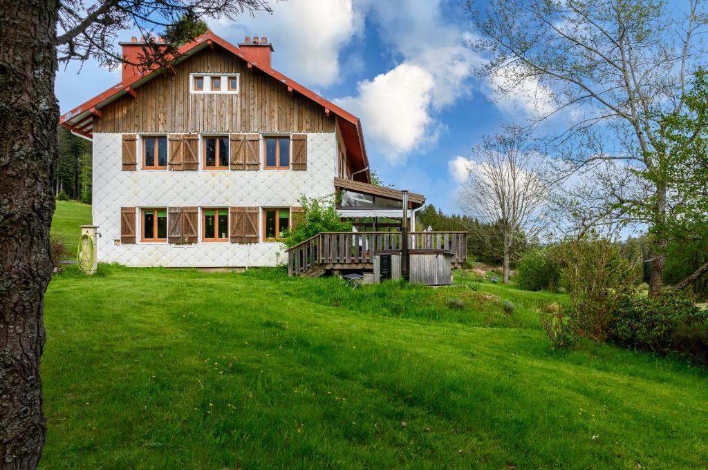 una casa en una colina con un patio verde en Gîte La Ramée en Ban-sur-Meurthe-Clefcy