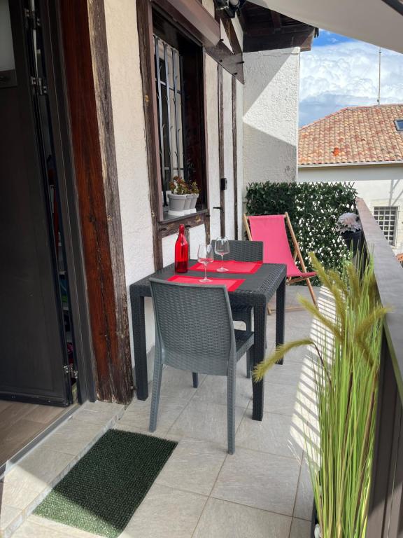 ein schwarzer Tisch und Stühle auf einer Terrasse in der Unterkunft Appartement Résidence Saint Jours - Centre ville in Vieux-Boucau-les-Bains