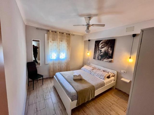 um quarto com uma cama grande e uma cadeira em Apartamentos FULL EQUIPPED em Elche