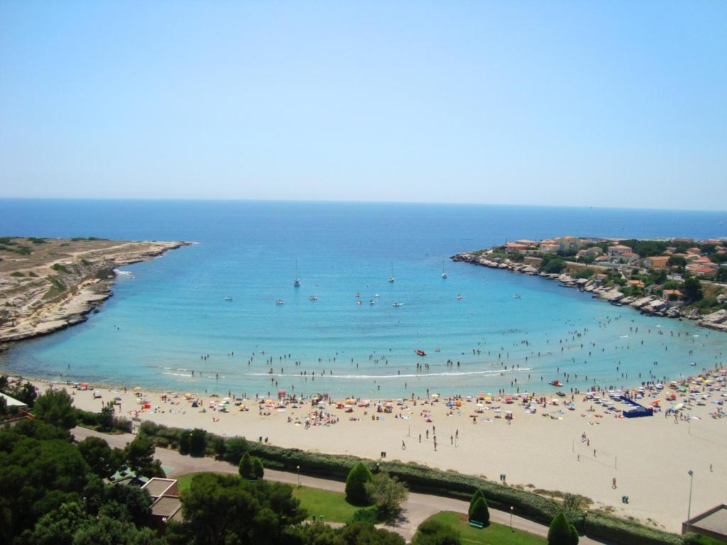 a beach with a lot of people in the water at Maison 6 personnes 3 chambres Aéroport-Plages in Marignane