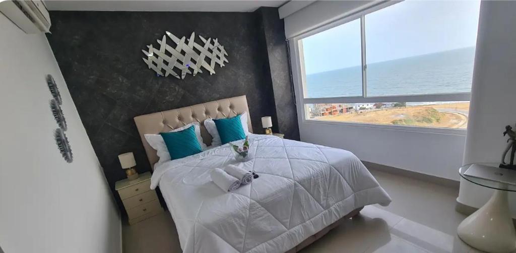 een slaapkamer met een groot bed en een groot raam bij Ecusuites playas torre pacific ll in Guayaquil