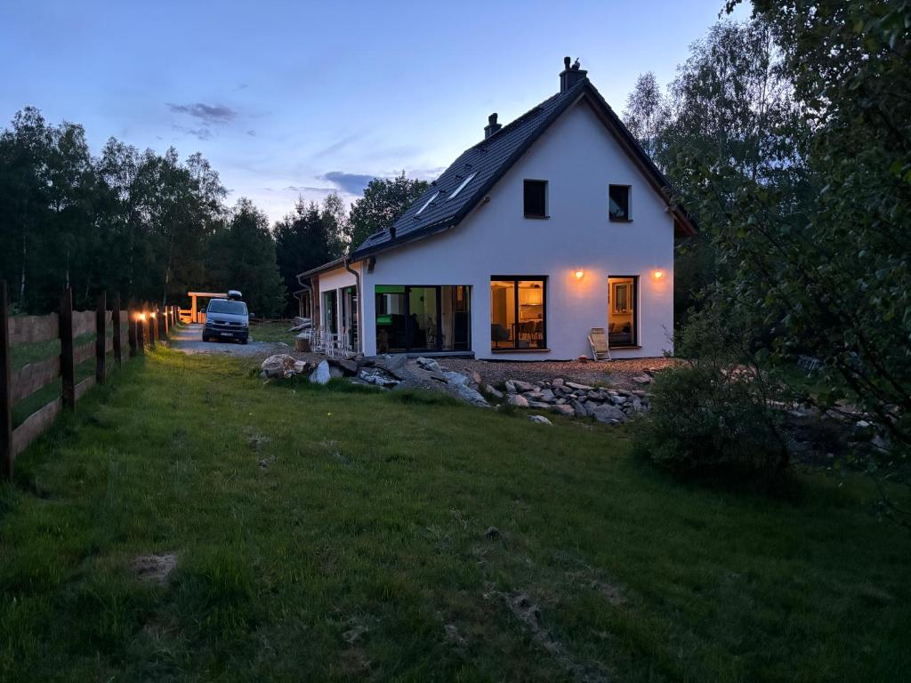 una pequeña casa blanca en un patio por la noche en Helenowa Polana en Stary Gieraltow