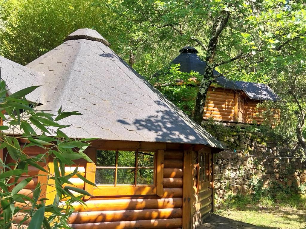 uma pequena cabana de madeira com telhado de palha em Natur'ânes em Mialet
