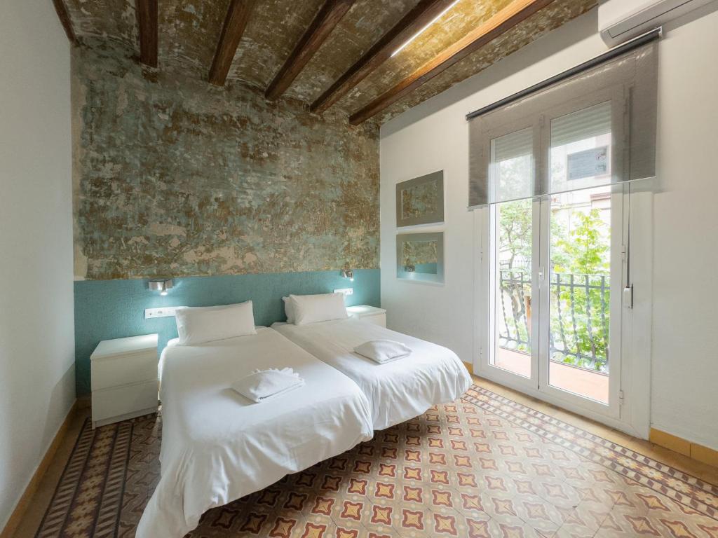 a bedroom with a large bed and a large window at Stay U-nique Apartments Nació in Barcelona