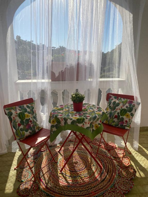 a table and two chairs in front of a window at villa martina suite apartament in Lacco Ameno