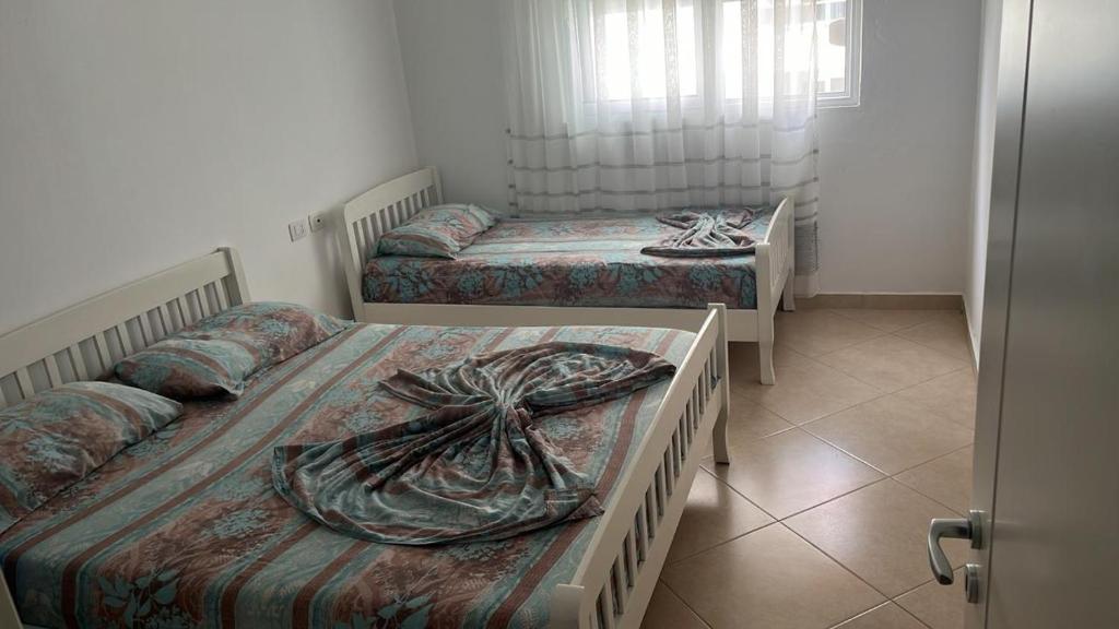 Dos camas individuales en una habitación con ventana. en TheCozyView1, en Lezhë