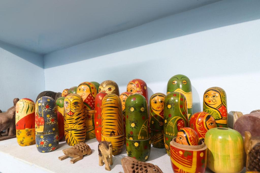 a group of colorful vases sitting on a shelf at OYO Flagship Sandhra Apartments in Pūvār