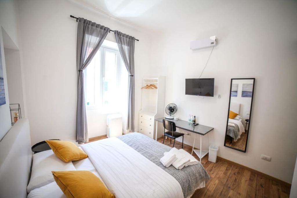 een slaapkamer met een bed, een bureau en een spiegel bij Cosmo GuestHouse in Rome