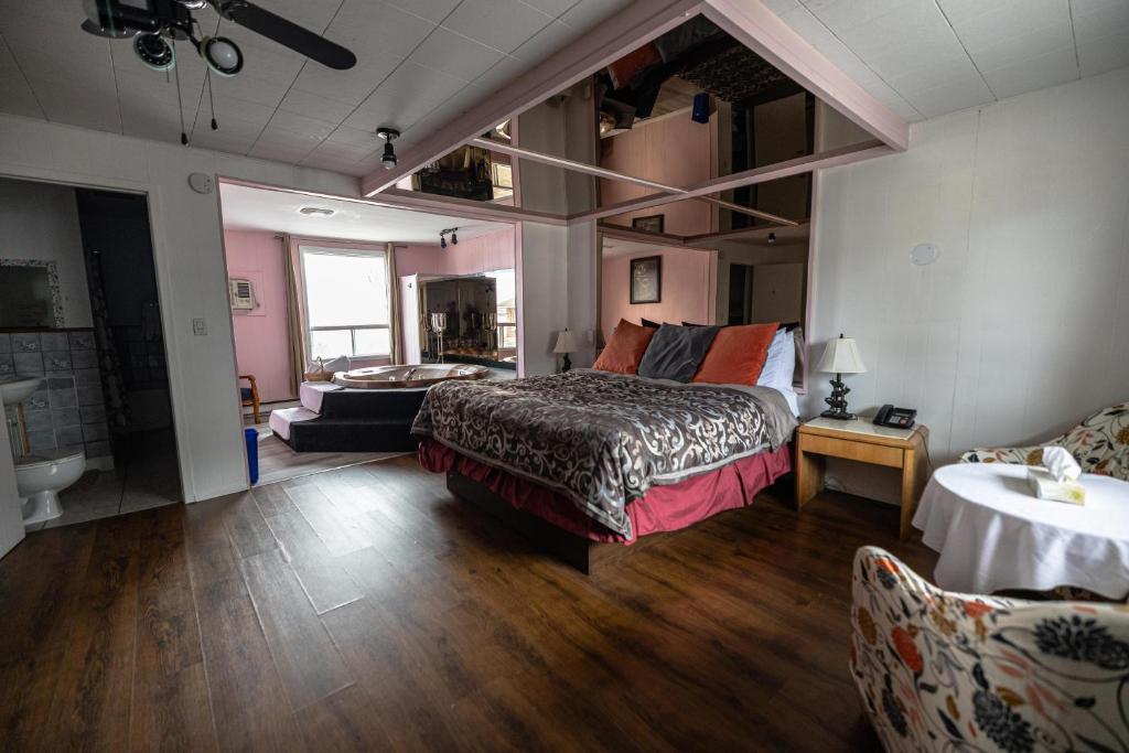 1 dormitorio con 1 cama y sala de estar en Motel Deblois, en Sainte-Anne-de-Beaupré