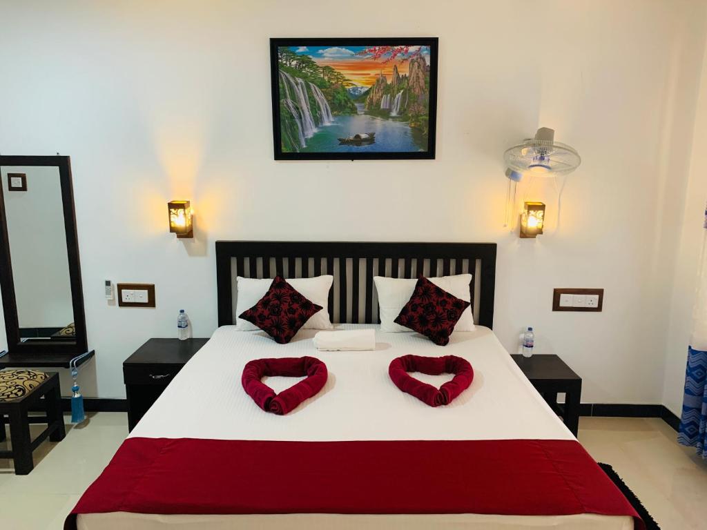 Lake Wind في هارابانا: غرفة نوم مع سرير كبير مع وسادتين حمراء