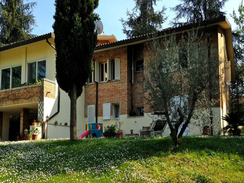 una casa con un árbol delante de ella en B&B Mama Rò, en Cesena