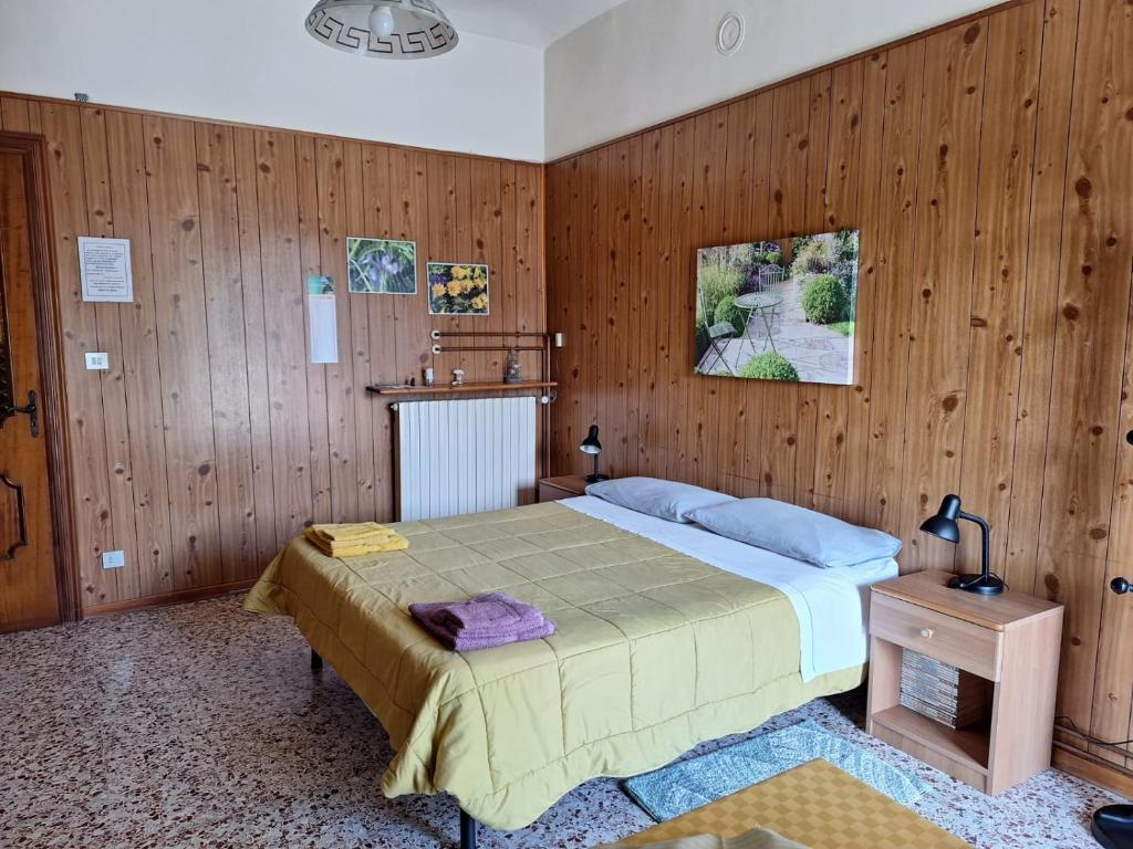 B&B Bertaina Mauro في Cavallermaggiore: غرفة نوم بسرير وجدار خشبي