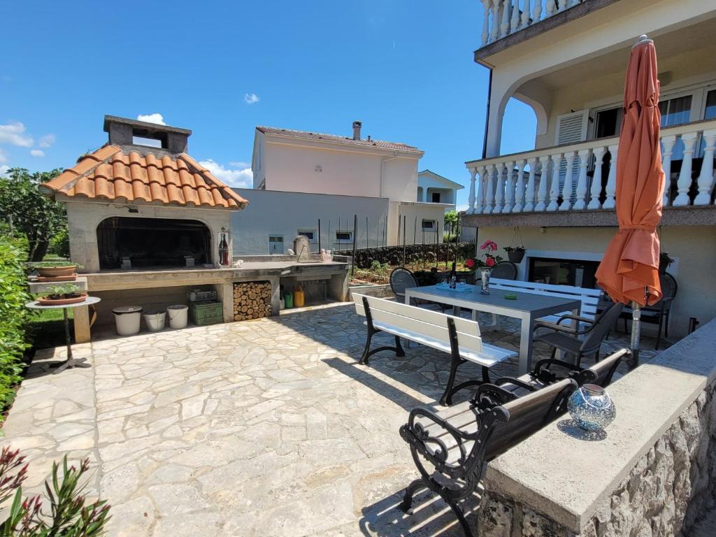 a patio with a table and chairs and an umbrella at Apartment Danica in Malinska