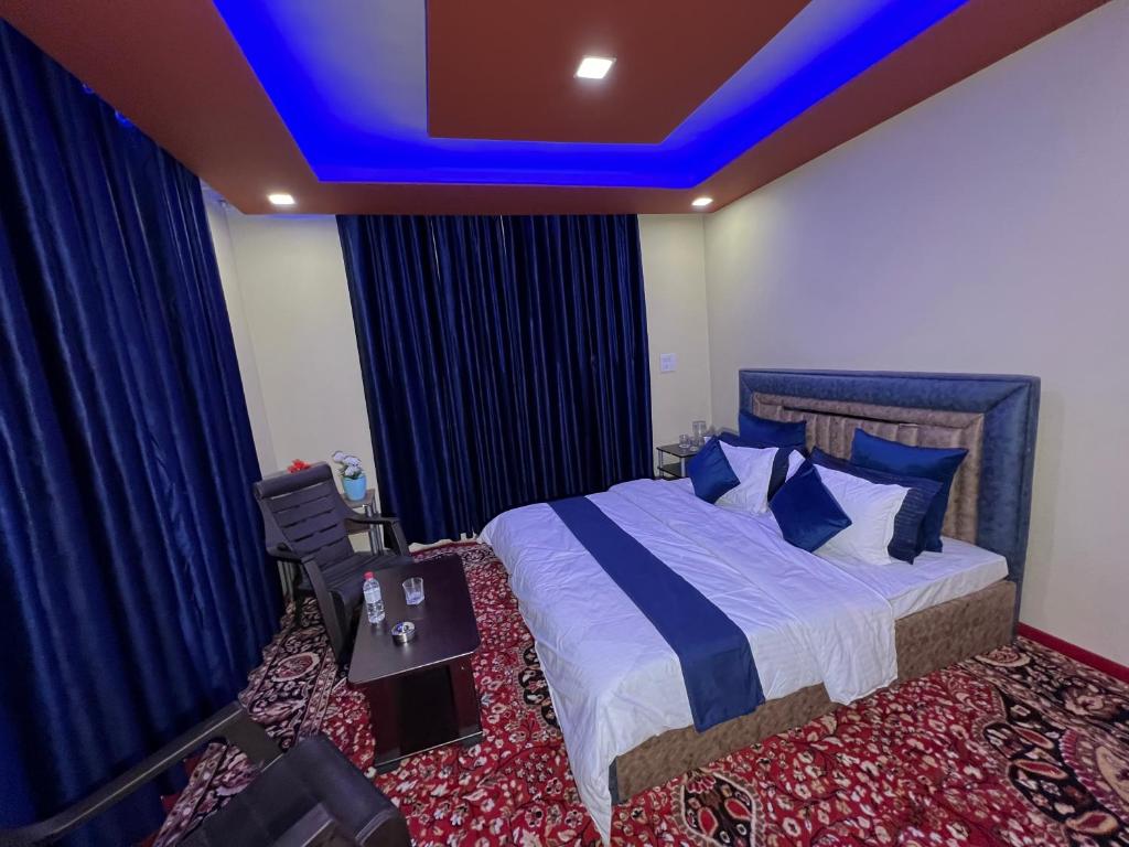 a bedroom with a bed with a blue ceiling at GUREZ GUEST HOUSE in Kanzalwan