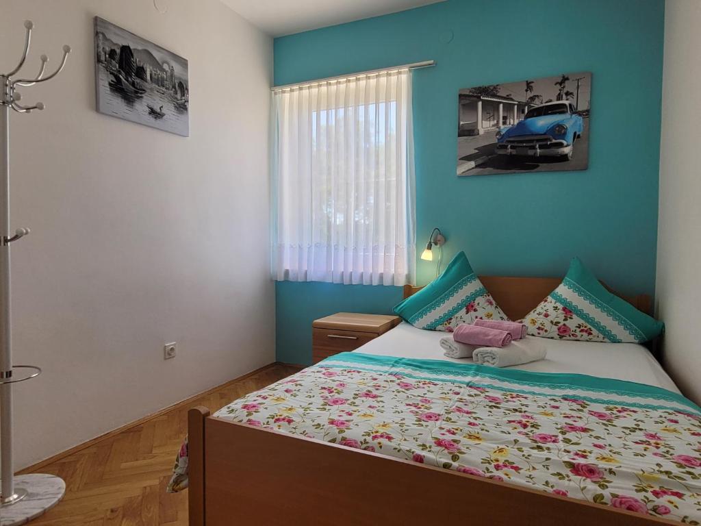 a bedroom with a bed with blue walls at Apartment Danica in Malinska