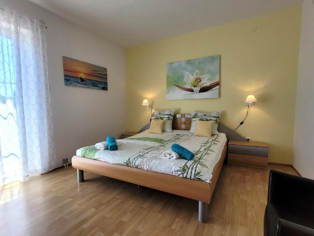 a bedroom with a large bed with blue pillows at Apartment Danica in Malinska