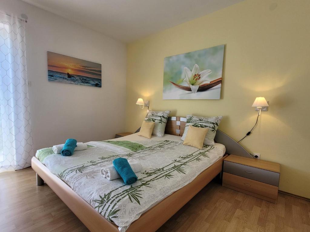 a bedroom with a bed with blue pillows on it at Apartment Danica in Malinska