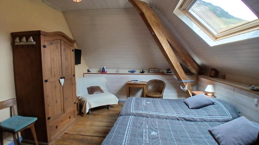 a attic bedroom with a bed and a window at Chambre d'Hotes La Mexicaine in Jausiers