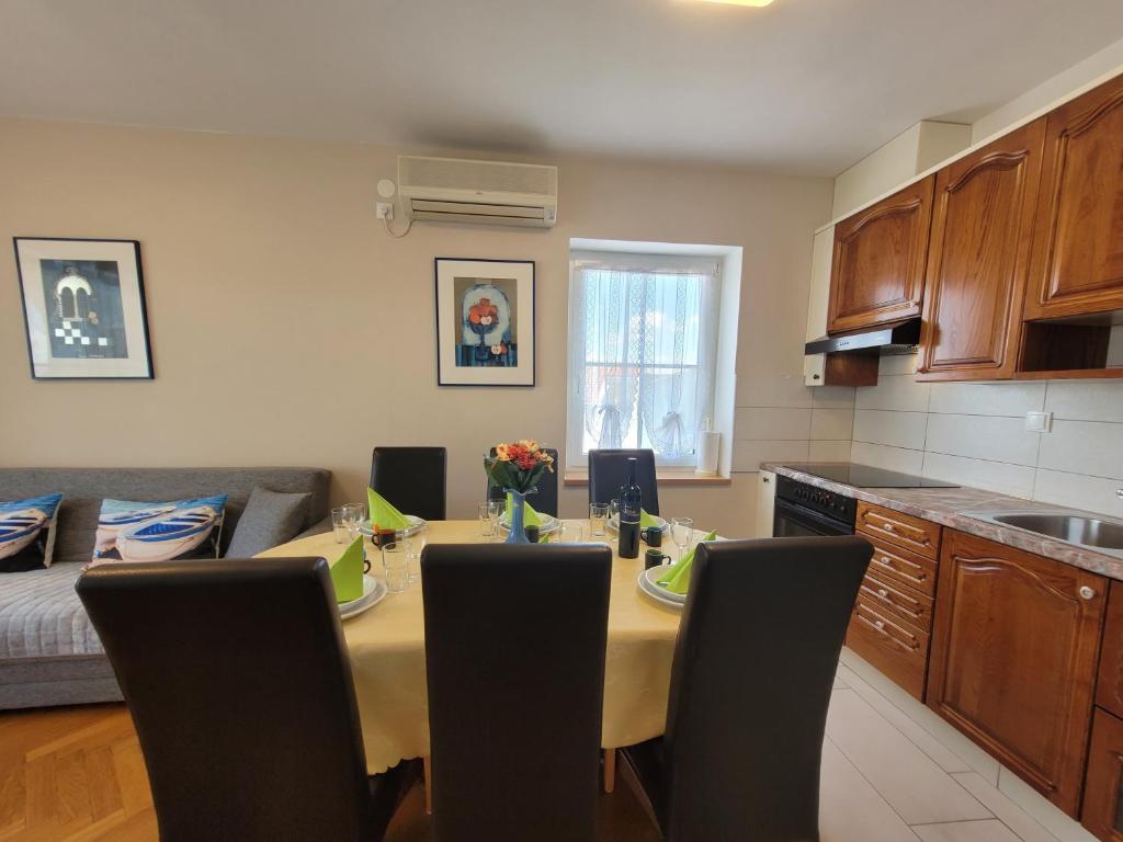 a kitchen with a table and chairs in a kitchen at Apartment Danica in Malinska