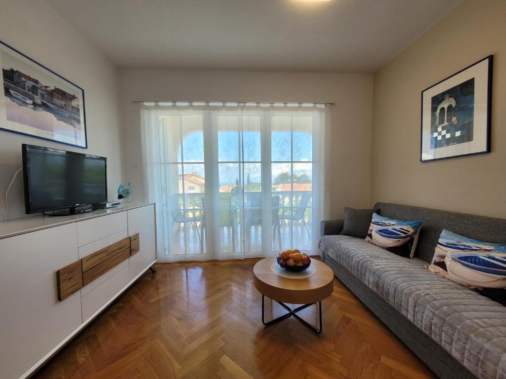 a living room with a couch and a tv at Apartment Danica in Malinska