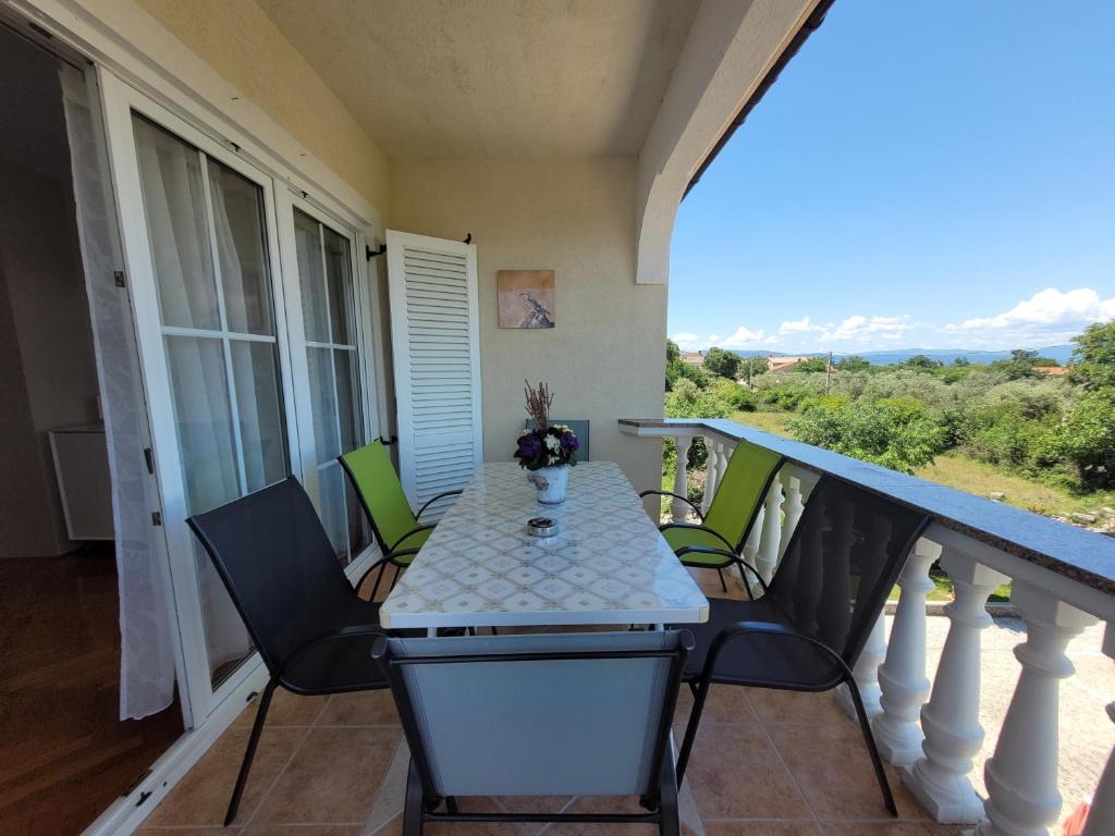 a porch with a table and chairs on a balcony at Apartment Danica in Malinska