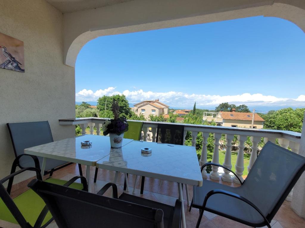 a table and chairs on a balcony with a view at Apartment Danica in Malinska