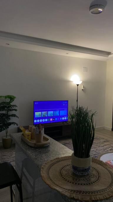uma sala de estar com uma televisão e uma mesa em شقة استديو فاخرة em Khamis Mushayt